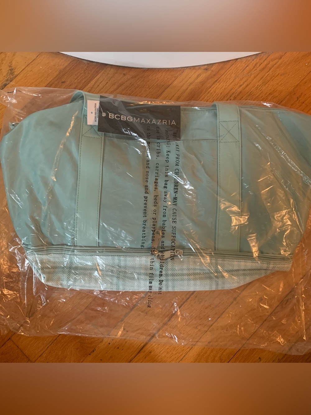 BCBGMAXAZRIA satchel bag features a light blue color and a plaid patterned base